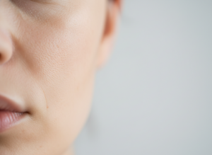 Zbliżenie na fragment skóry twarzy, ukazujące subtelne różnice w kolorycie, symbolizujące przebarwienia na twarzy.