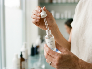 Dłonie profesjonalisty trzymające buteleczkę z roztworem kwasu pirogronowego w klinice dermatologicznej.